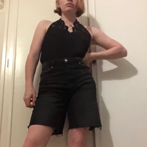 Svart linne med spets - Går runt halsen och är öppen den övre delen av ryggen. Oanvänd och i storlek L. Den sitter lite konstigt på sista bilden för att den är för stor.