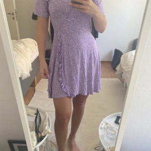 Lilablommig klänning  - Klänning i mjukt material som faller väldigt fint. Knappt använd. Köparen står för frakten (ca45-50kr). Den är liten i storleken, det är en strlk M men passar mer som en S. 