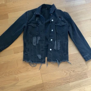 Svart jeans jacka - Snygg svart jeans jacka från HM me slitna hål på       Påassar nästan vem som helst beror på hur stor eller liten man vill ha den :)   