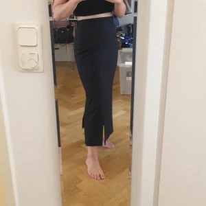 Svart långkok, Strl 38 - Svart långkjol i fint skick. Kjolen har en slits till vänster framtill o en slits i mitten baktill. Stängs med blixtlås o knapp baktill. Går till över anklarna på en som är ca 160 cm. Möts gärna i Sthlm. Köparen står för frakten.