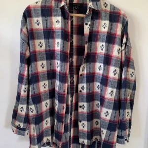 Längre flanell i storlek 34 - Härlig flanell från märket Atmosphere med slits i sidorna.