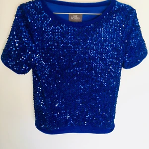 Kornblå glittertopp - Kornblå glittrig topp, använd 1 gång. Som ny! Köpt på Nelly.