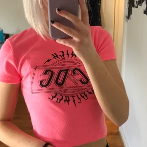 Tröja med tryck  - Snygg kort neon rosa använd tröja med acdc tryck. Passar perfekt både på sommar och vinter, skulle säga att den passar xs/s