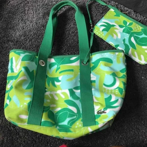  - Lacoste bag/väska med tillhörande sminkväska. Som ny! Använd två gg.  Finns i Nacka. Köpare står för frakt. 