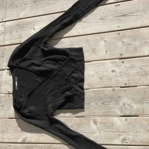  - Stickad crop top med omlott/v-ringning. Fint skick. Kan skickas, köparen står för frakten. Hämtas i Onsala.