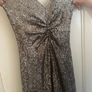 Klänning  - Denna glänsande silverklänning är helt ny och redo att lysa upp vilken fest som helst! Ordinarie pris 3699kr