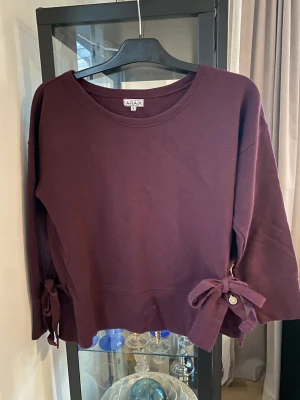 Tröja - Tröja från Ajlajk, strl M Vinröd med knyt i båda sidorna I fint skick 