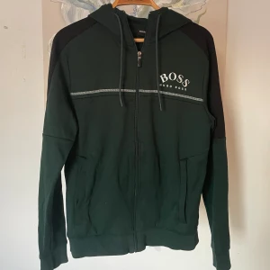 Hugo Boss Zip Hoddie - Grön Hugo boss zip hoddie, nästan helt oanvänd. Finns ej kvar i butik. Storlek S
