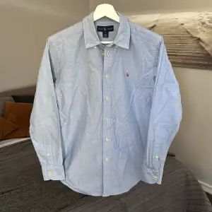 Ljusblå Polo Ralph Lauren skjorta i felfritt skick! Storlek 16, skulle säga att det sitter som S slim fit! Nypris runt 1700kr.