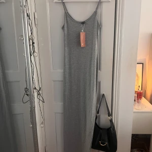 långklänning - Superfin grå långklänning i str s som aldrig är använd. Perfekt till sommaren🥰