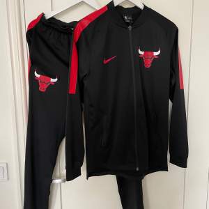 Chicago Bulls-tracksuit från Nike som säljes på grund av att det inte kommer till användning.  Storlek: S Skick: Väldigt bra Mått underdel: midjemått 74cm, ytterben 102cm, innerben 75cm. Överdel: plagglängd 68cm, bröstvidd 86cm, ärmlängd 54cm (armhål