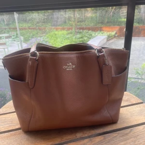 Coach väska - Äkta coach väska i brunt skinn. Rymling och man får plats med en dator. Bara använd några få gånger. 