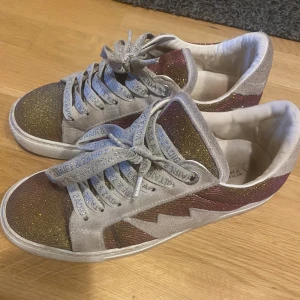 Zadig & Voltaire sneakers La Flash - Säljer mina Zadig & Voltaire sneakers i storlek 38 då de inte använda längre. Inköpta 2023, endast silver säljs nu. Använda men har inte tappat passformen. Viss slitage på tyget (kan skicka bild). Nypris 3800. Dustbag och låda.