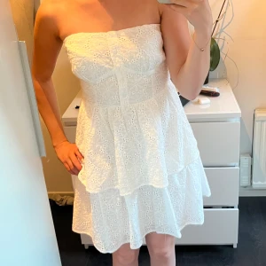 Vit klänning  - Hej <3 Säljer denna supersnygga vita korta bandeu klänningen från NAKD. Passar perfekt till student, skolavslutning eller bara som en fin sommarklänning. Skulle haft som studentklänning men säljes då jag hittade en annan! Helt oanvänd med prislapp 💗