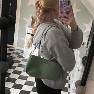 Väska - En axelväska i en fin grön färg som är såå fin till sommaren🌷✨ Använd nån enstaka gång. Den rymmer en hel del men är ändå inte för stor vilket är bra🫶 Båda banden ingår! Hör av dig vid funderingar!!💕
