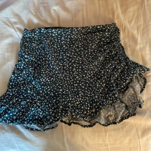 Somrig blommig kjol! - Säljer min kjol då den börjar bli för liten för mig!  Den har ett litet hål vid dragkedjan men annars i bra skick! Den är i storlek XS men kan andvändas som en mini kjol.  Kontakta gärna vid fler frågor eller bilder!☺️