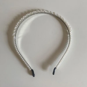 Diadem med pärlor - Ett elegant diadem dekorerat med vita pärlor. Diademet har en smal form och är perfekt för att ge en sofistikerad touch till din frisyr!