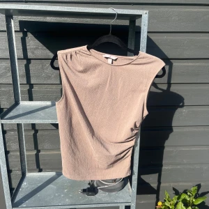 Beige topp  - Beige topp med snygg indragning i midjan och med hög nacke! Helt oanvänd 