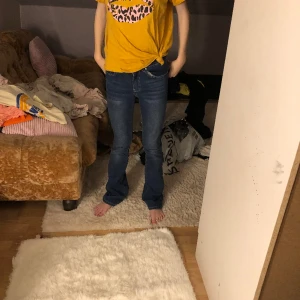 Gul T-shirt  - En gul T-shirt med ett par rosa läppar med svarta prickar och en liten Knut vid magen