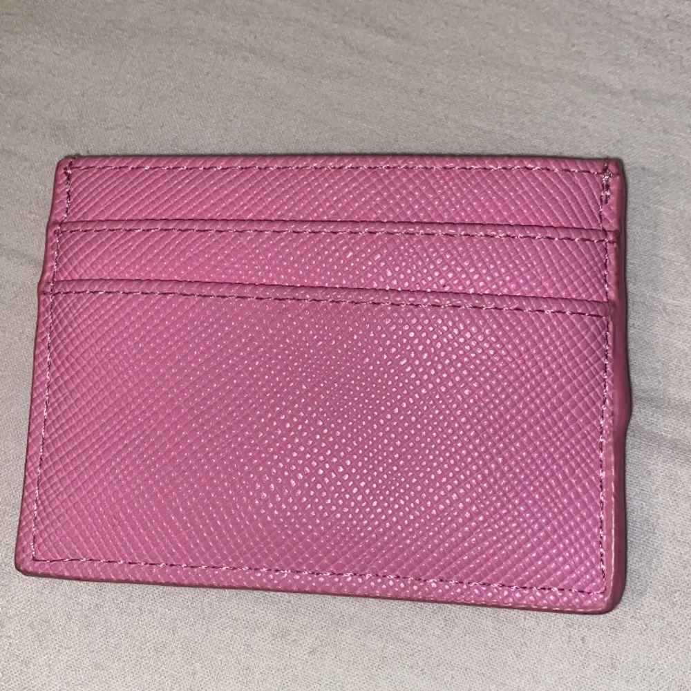 Det är en liten rosa plånbok från don donna. Den är helt ny.. Accessoarer.
