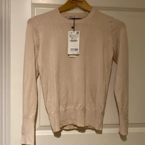Ny långärmad beige top Zara  - Säljer en helt ny långärmad topp från Zara med lappen kvar . Aldrig använd  Knappar vid ärmslut. Nypris 299