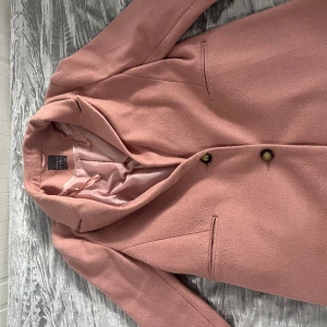 Ros kappa  - Säljer denna unika rosa kappa för 400kr. Väldigt fin och elegant till antingen vardagen eller till en utekväll. Knälång ungefär 