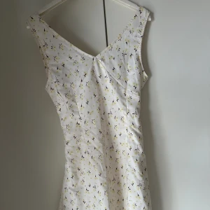 Sommarklänning - säljer denna helt oanvända klänningen i satinliknandetyg. Går att skjutdörrs i midjan bak med snöre som man knyter till en rosett. Säljer då den är lite liten runt bysten. Aldrig använd klänning. Köpt för 200kr säljer för 80kr🩷