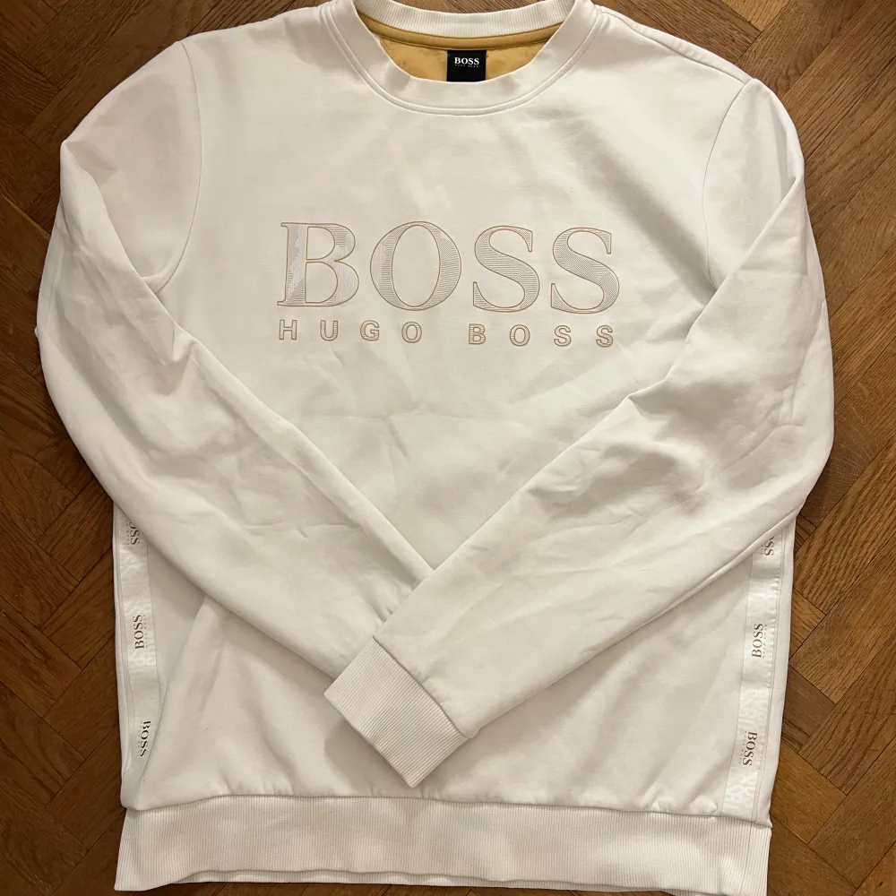 Väldigt fin vit Hugo Boss tröja med guldiga detaljer storlek M  Knappt använd endast fåtal gånger. Tröjor & Koftor.