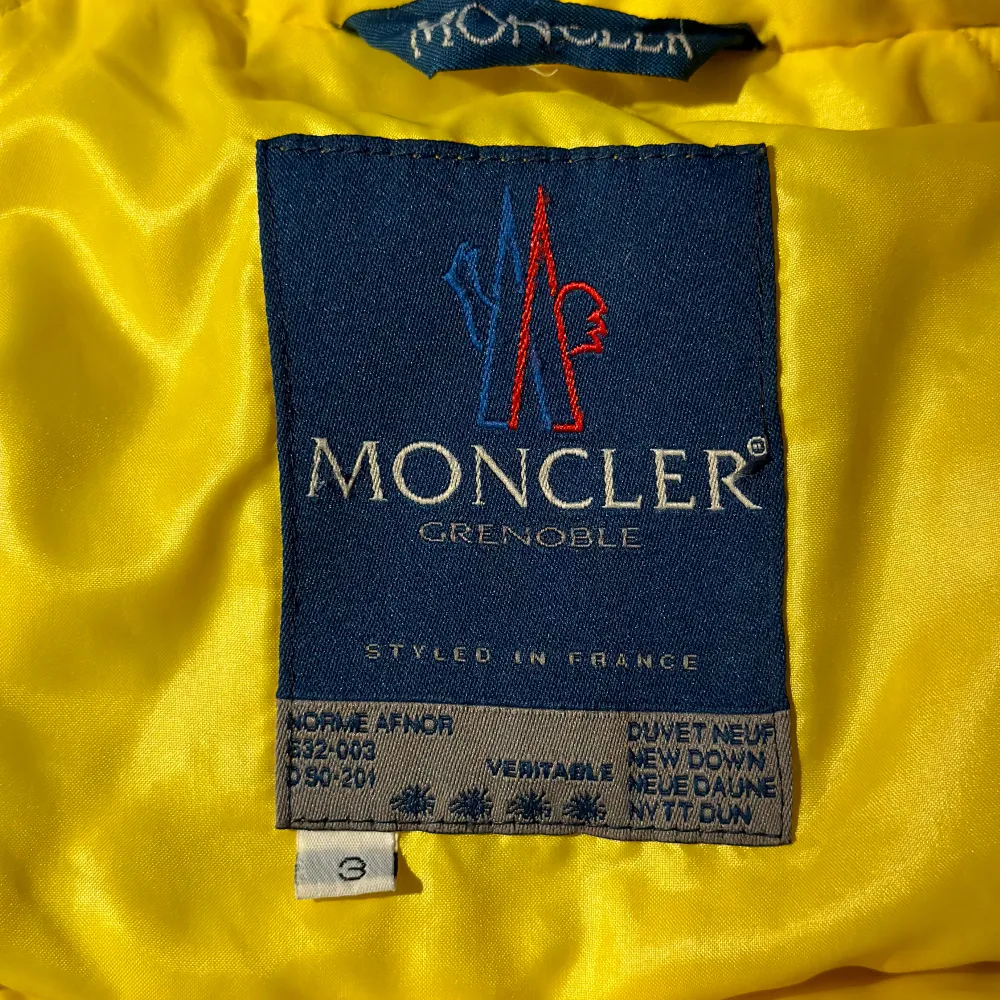 MONCLER dunjacka i härlig gul färg. Strl 3. (Upplevs som en rymlig 38/40) Förra ägaren har sprättat bort Monclermärket på armen (se bild) samt gjort en lagning på framsidan där nu en broderad blomma sitter. Jackan är i fint skick.. Jackor.