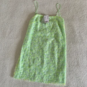 H&M limegrön paljettklänning / miniklänning - Otroligt snygg klänning med paljetter från H&M. Ny med tags kvar. Utan anmärkningar.