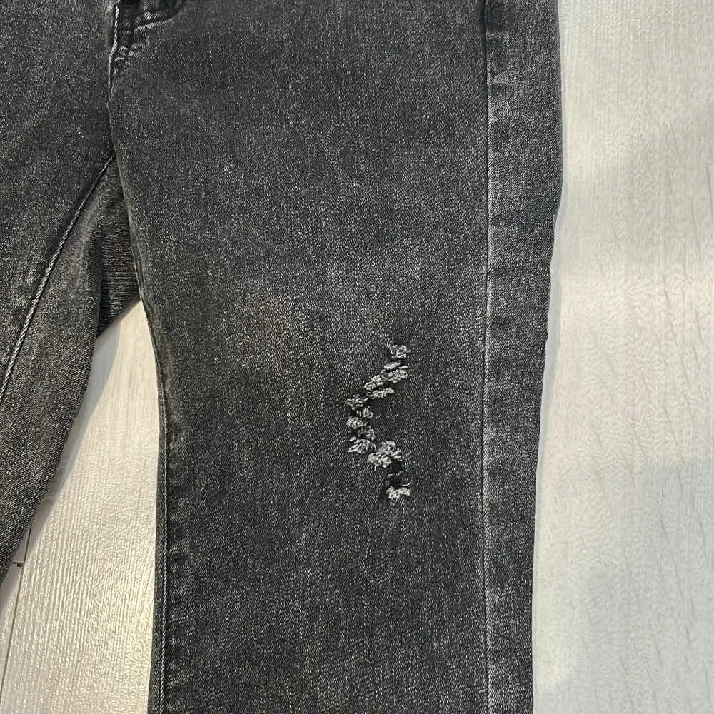 Stretchiga grå Utsvängda byxor med en detalj på låret. Använda 1 gång💕. Jeans & Byxor.
