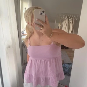 Topp - En jättesöt lila topp med knytning på ryggen. Superfin till sommaren och i jättebra skick! Säljs då den inte kommit till användning!❤️