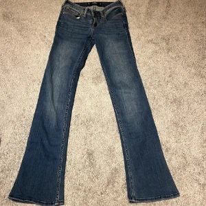 Blå jeans från Hollister - Ett par jättefina blå jeans från Hollister i modellen Low-Rise Boot och fina detaljer på bakfickorna🫶🏻. Bilderna är från förra ägaren och säljs då de var för små. om ni har några funderingar tveka inte att fråga😊
