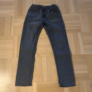 Svart grå Levis 512, stil 164 - Använt i fint skick, passform Slimfit Levis 512 storlek 164.