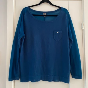 Turkos tröja från Rituals i strl L - Turkos tröja från Rituals i strl L  Tröjan har genomskinligt tyg runt halsen samt delvis på armarna.  Använd men i fint begagnat skick   Mått Över bröstet: ca 56 cm Längd från axeln och ner: ca 68 cm  60% bomull, 20% viskos och 20% nylon