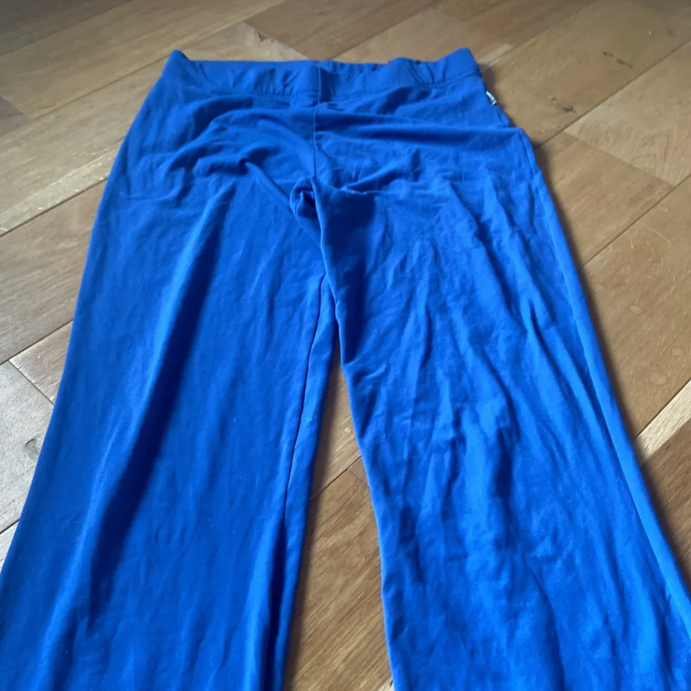 Säljer ett par blå yoga pants byxor från SOC i storlek M. Byxorna är bootcut De är gjorda av ett mjukt och stretchigt material som består av polyamid och lycra, vilket gör dem bekväma att ha på sig. Perfekta för både vardag och träning!. Jeans & Byxor.