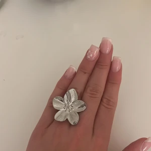 Silvrig blom ring - Beställde från en tjejs hemsida men passade ej. Den går bara att justera större.