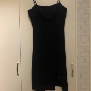 Svart snygg sexig klänning som sitter tight på kroppen, smala Band och fin design vid bröstet samt en slits på vänster sida som ger det lilla extra. Har endast använts en gång. 