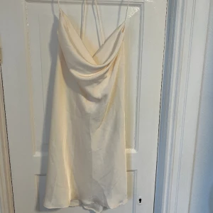 Satinklänning Zara - Mycket fin benvit festlig klänning från Zara. Aldrig använd, prislappen sitter kvar. Perfekt till sommarens festligheter. 