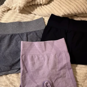 Träningsshorts  - Säljer dessa 3 snygga träningsshorts i färgerna lila, grå och svart. De grå och svarta shortsen är i storlek M och har inte någon “scrunch” i rumpan men de lila är i storlek S och har det! 79kr/st☺️  ‼️LILA = SÅLD & SVART= SÅLD ‼️‼️‼️