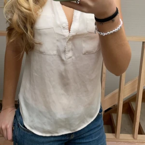 Vit blus  - Vit blus med lite detaljer i storlek s