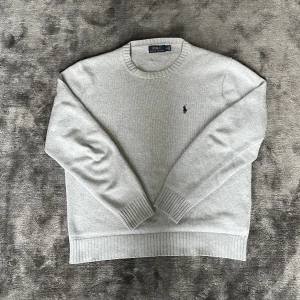 Ralph Lauren tröja - Säljer min feta Ralph lauren tröja i storlek M. Den är ljusgrå med svart häst. Är i bra skick och har måtten på andra bilden så kan ni jämföra hemma😁