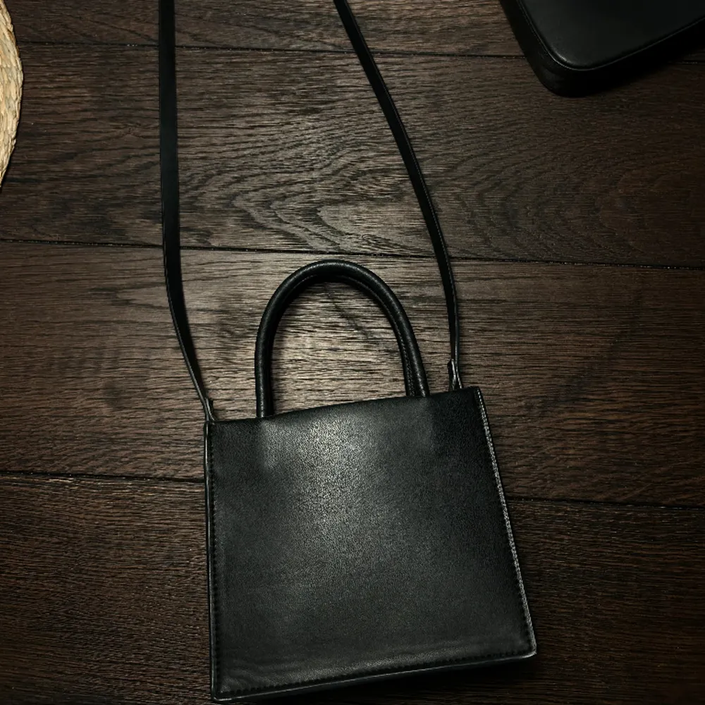 En svart väska från H&M.. Väskor.