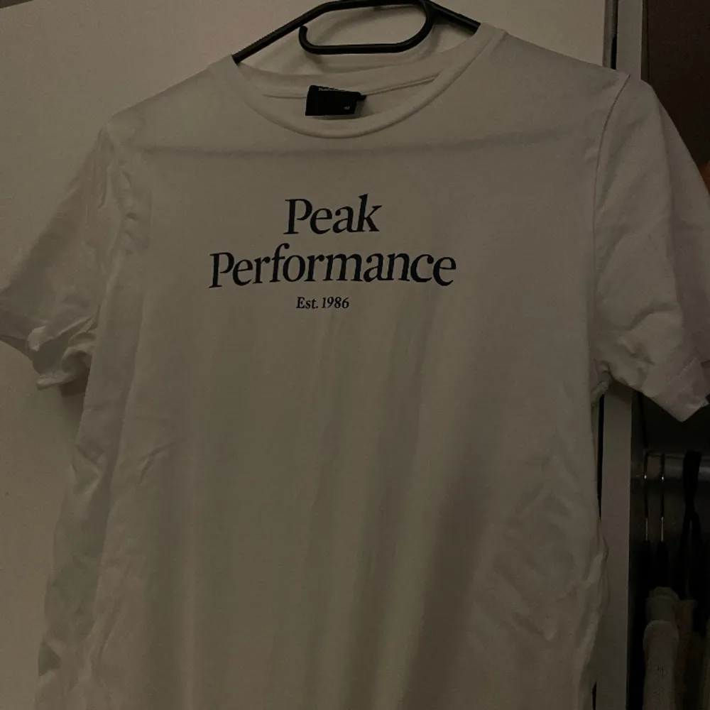 Peakferformance t-shirt i vit med marinblå text. Tveka inte höra av er vid ytterligare funderingar ☺️. T-shirts.