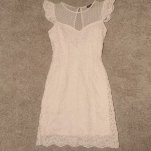 Vit klänning - En superfin klänning, perfekt för studenten. Är i storlek 34 och har spets och med dragkedja och knapp bak. I superfint skick. Bara att höra av sig för mer info☺️