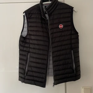 Colmar väst  - Colmar väst Storlek 50 passar mig som är 182cm Färg svart Cond 9/10 på utsidan, insidan 6-7/10 - fått skumma gul/bruna streck på insidan, kan vara solblekt. Visas på bild 3 