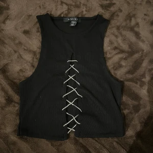 Topp - Ribbad topp med små kristalldetaljer på snörningen 