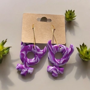 Bad girl. Polymer lera örhängen - Egentillverkade örhängen av polymer lera. Venus symbol med små horn.  Hoops av rostfritt stål. Mycket enkla att byta ut om man så önskar. Putsade och polerade. Naturlig glans.  Mycket lätta. Designade och gjorda av mig själv.