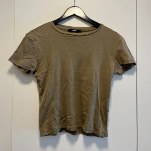T-shirt  - Militärgrön stretchig t-shirt. Använd men i gott skick. Köpt på BikBok. Passar S/M.