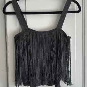 Glittrigt linne med fransar - Riktigt snyggt att ha på fest. Använd en gång, så helt i nyskick. Svart och glittrigt.🪩 